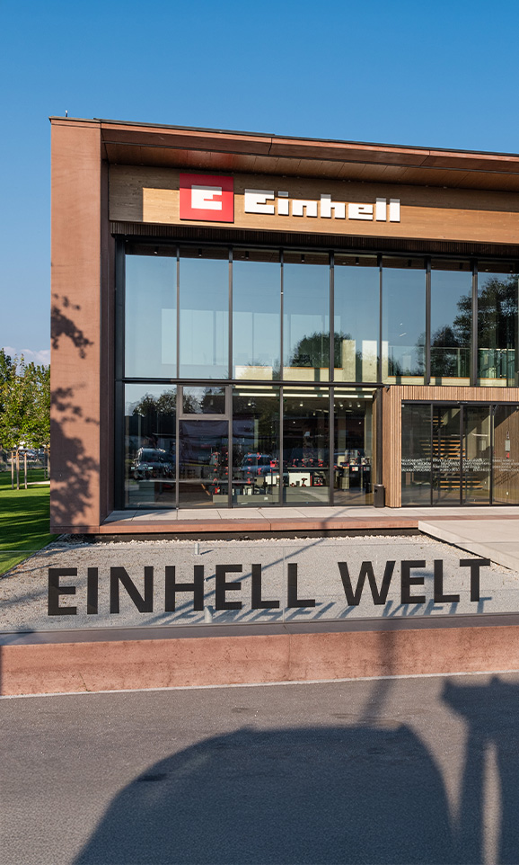 Mundo Einhell: edificio moderno de empresa con el logo de Einhell y un gran grupo de empleados.
